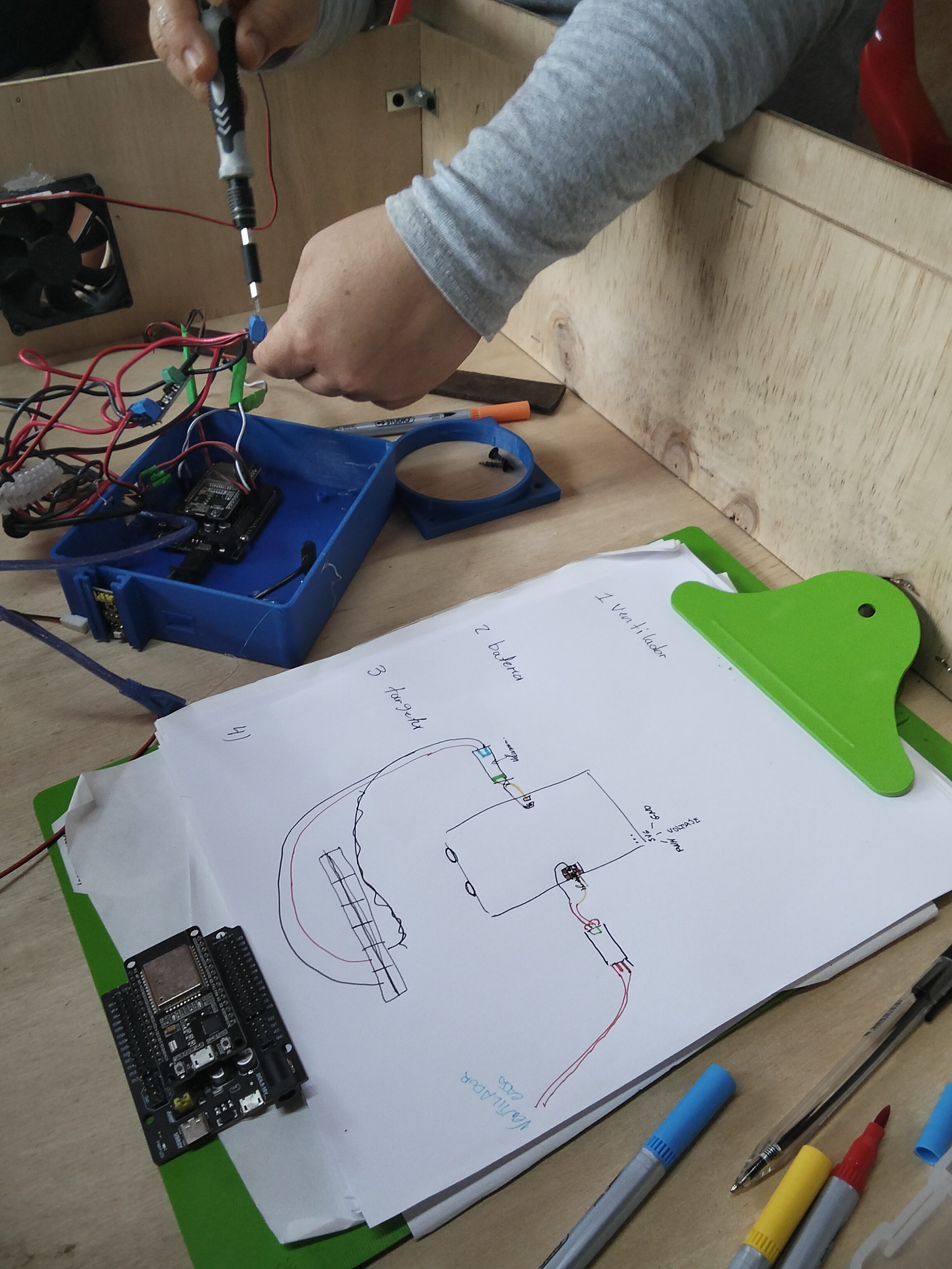 Esquema dibujado a mano junto a componentes electr&oacute;nicos y cableado.